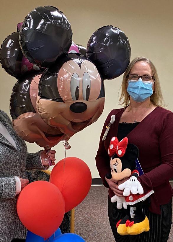 Woman wearing Mickey Shirt beside Mickey Mouse Balloons